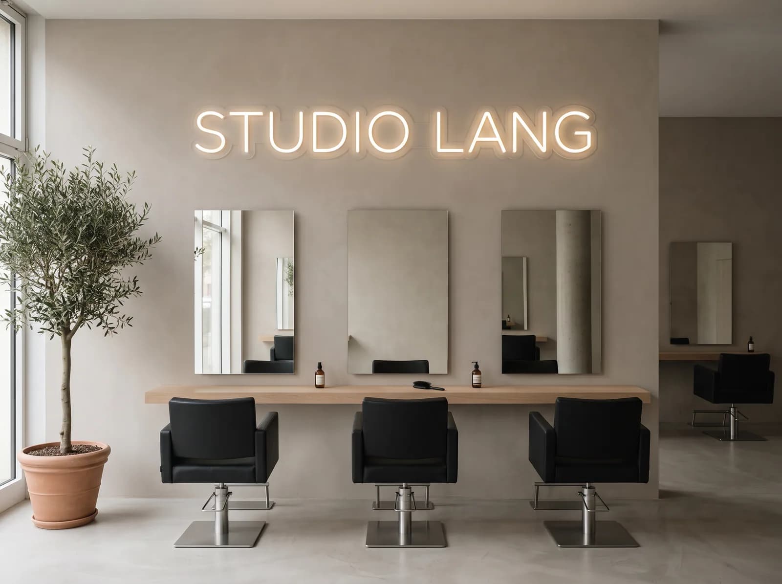 Warmweißer Neon-Schriftzug an der Wand eines Friseursalons, darunter die Frisierplätze mit Spiegeln