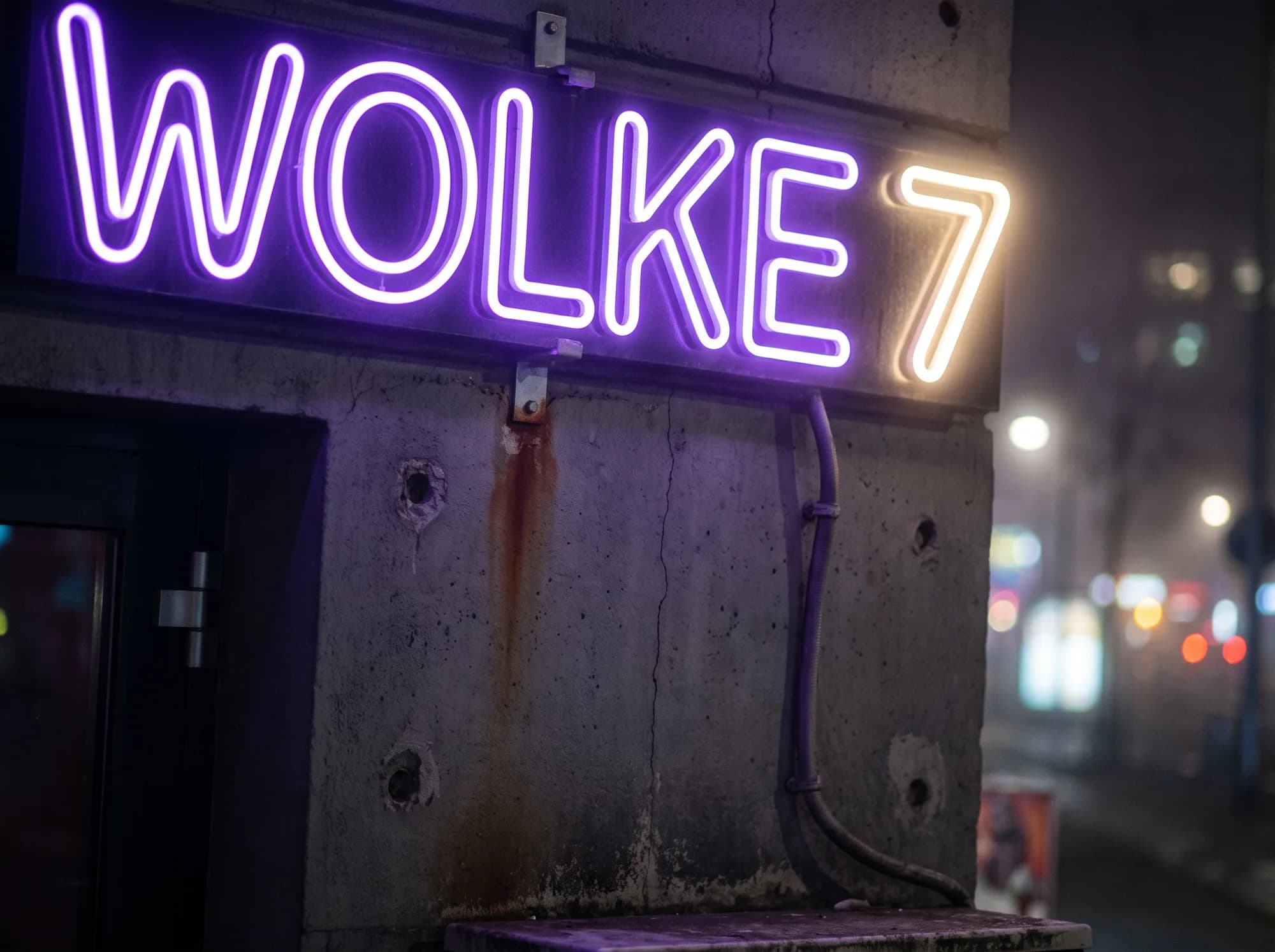 Violet neon lettering on a concrete wall beside the entrance of a shisha bar